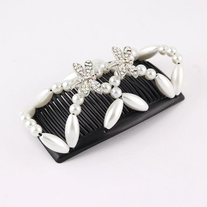 Detailed view of silver dragonfly hair comb with white pearls and sparkling rhinestones