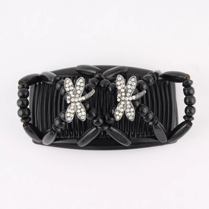Detail of beaded hair comb with two sparkling rhinestone dragonfly ornaments on white background