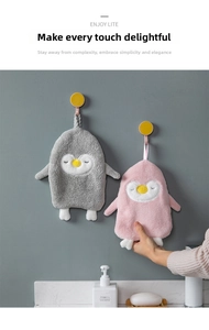 Close-up of soft penguin-shaped hand towels with embroidery and hanging loops