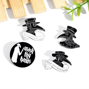 Detailed macro view of black plague doctor enamel pins on a minimalist wooden background