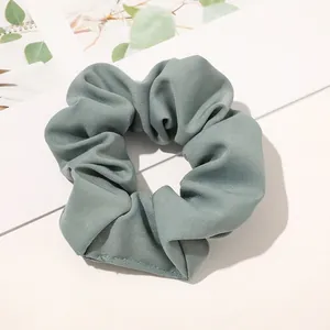 Detailed view of Morandi bean green twill fabric scrunchie with elastic inner band