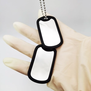 Close-up of double stainless steel military dog tags with black rubber silencers on ball chain