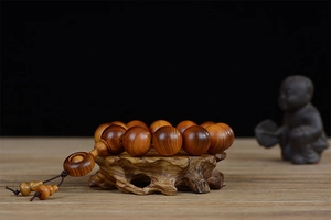 Macro detail of Thuja sutchuenensis wood prayer beads on a wooden display stand