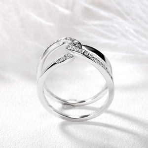 Detailed close-up of a silver-toned double interlocking ring with zircon pavé accents