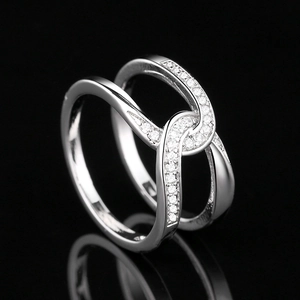 Minimalist silver double-cross ring with pavé zircons on black reflective background