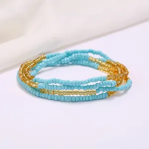 Close-up of handmade multilayer sky blue and gold beaded waist chain for summer beach style