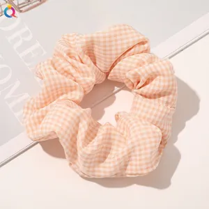 Detailed close-up of orange and white checkered fabric scrunchie on a magazine page