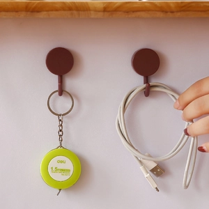 Rotating 3-branch adhesive hooks in brown plastic installed on tile wall for storage