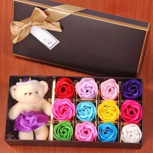 Detail of colorful soap roses and a plush teddy bear in a black romantic gift box