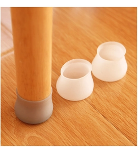 Macro shot of circular silicone chair leg protectors on a light wooden floor surface