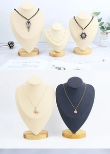 Detail of wooden necklace busts in cream and black with natural solid beechwood bases