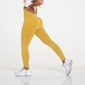 Detail of high waisted seamless yoga leggings in bright yellow with peach butt lifting effect