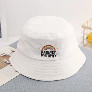 Detailed close-up of rainbow embroidery and Radiate Positivity slogan on white cotton hat