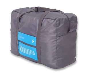 Macro view of grey nylon folding travel bag with blue zipper pocket and plane logo