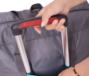 Detail of grey foldable travel bag showing the suitcase handle sleeve for easy carrying