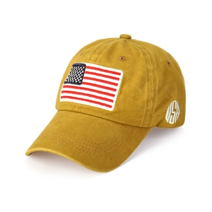 Detailed view of American flag patch and USA embroidery on mustard yellow cotton baseball cap