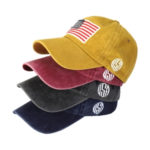 Detail of four vintage cotton baseball caps in yellow, red, grey, and navy with USA patch
