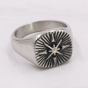 Macro detail of silver steel signet ring with radial star motif and central zircon stone