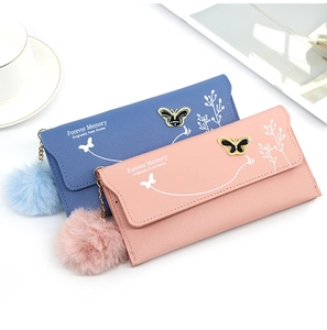 Detail of elegant ladies long wallets with floral patterns, butterfly clasp and soft pom-pom
