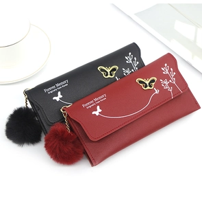 Detail of long leather wallets with butterfly hardware and plush ball keychain charm