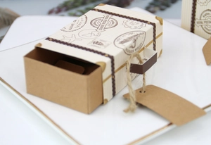 Detailed close-up of mini vintage suitcase favor box with luggage tag and hemp rope