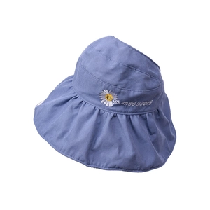 Close-up of white daisy embroidery and yellow smiley face on purple sun hat fabric