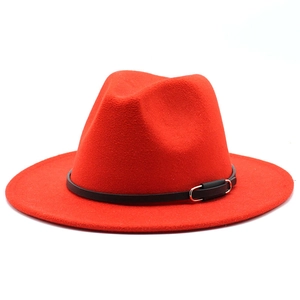 Detail of red wool fedora hat featuring black leather band and gold metal buckle detail