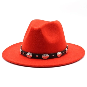 Detailed shot of red fedora hat with black belt and decorative silver metal studs