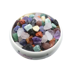 Assorted natural crystal raw stones in a white lotus ceramic bowl with vivid colors