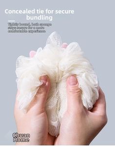 Close-up of white high-density mesh bath sponge being squeezed to show texture and elasticity