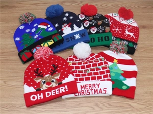Flat lay of seven colorful LED light-up knitted Christmas hats with festive patterns