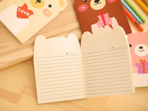 Close-up of cute bear-shaped notebook pages with horizontal lines and date section