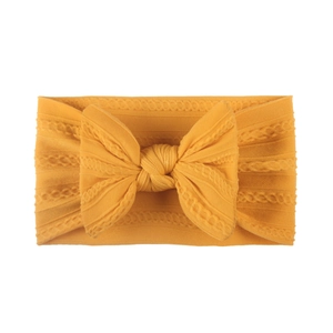 Detailed knit cable texture and large bow on a yellow soft elastic baby headband