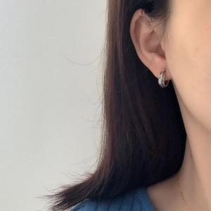Macro shot of silver woven texture ear cuff on model showing delicate metallic details
