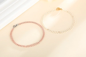 Gros plan de bracelets bohèmes à double rangée de perles avec fermoir mousqueton rose et blanc