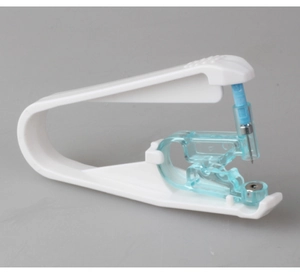 Detail view of the internal mechanism and stainless steel needle of a white ear piercing gun