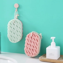 Detalle de esponjas de baño exfoliantes suaves en rosa y verde con cuerdas para colgar