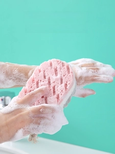 Detail van roze douchespons met rijk schuim en netstructuur voor effectieve exfoliatie