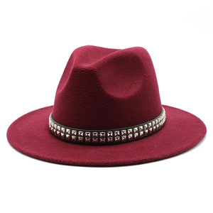 Détail d'un chapeau fedora en laine bordeaux avec ruban en cuir noir et clous dorés