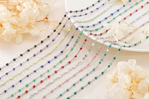 Detail of silver titanium steel chain necklaces with colorful resin beads in various shades