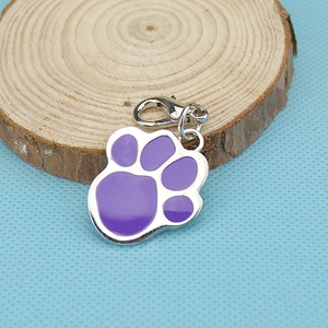 Purple paw print zinc alloy pet tag with lobster clasp on a rustic wooden base