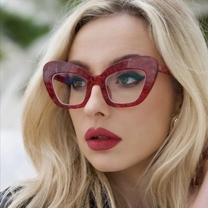 Close-up of stylish red cat-eye oversized glasses frames on a female model face