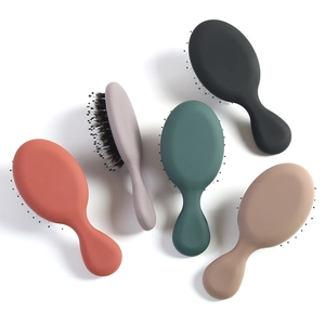Detailed view of portable mini hairbrushes in five colors on a clean white background