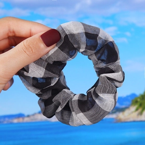 Close-up of lightweight black and white checkered scrunchie with sheer organza texture