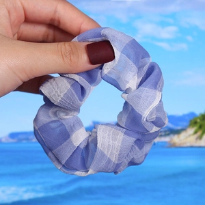 Detailed view of blue and white checkered organza scrunchie with soft pleated texture