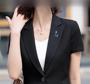 Detail of a colorful parrot brooch with crystals on a black suit jacket lapel