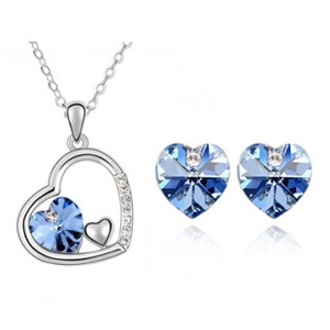 Détail de parure cœur en argent avec cristaux bleus incluant collier et boucles d'oreilles
