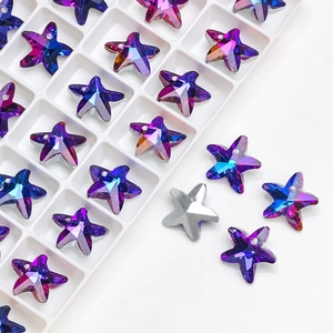 Macro shot of colorful star-shaped crystal charms in purple blue and silver finishes