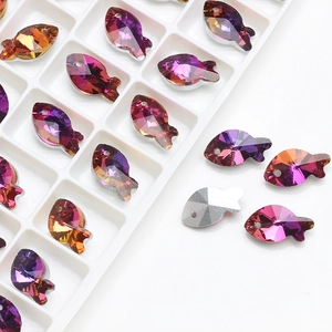 Macro shot of fish-shaped gradient crystal beads in a white tray for DIY jewelry making