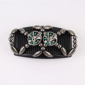 Detail of beaded magic hair comb featuring green tree of life design on black base